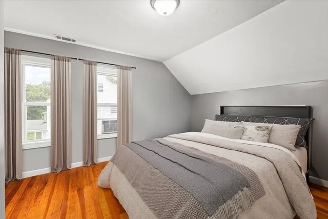 a bedroom with a bed and wooden floor