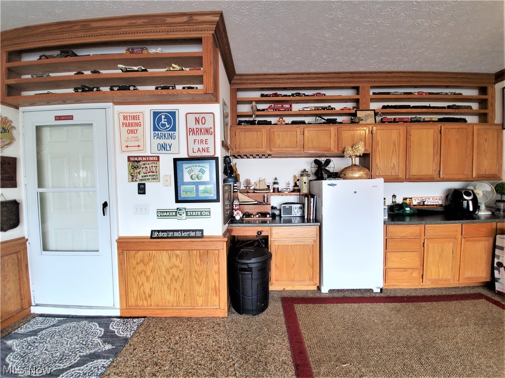 2347 Roxbury Road Avon, OH 44011 - Photo 29 of 35 Spectacular finished garage has a baseboard heater, Nature Stone flooring, crown molding, abundance of storage cupboards and display shelving, freezer stays with the home!