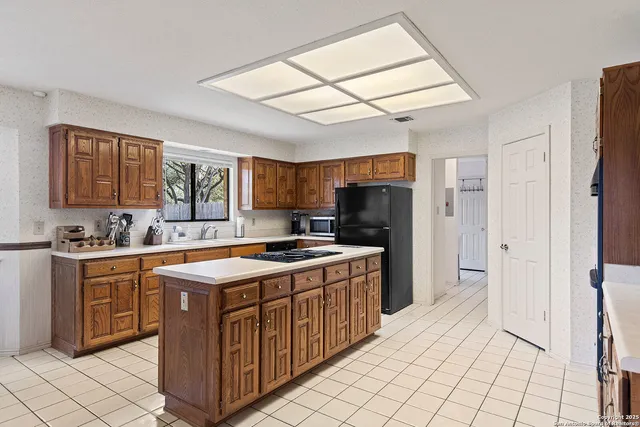 a kitchen with stainless steel appliances granite countertop a stove refrigerator and cabinets