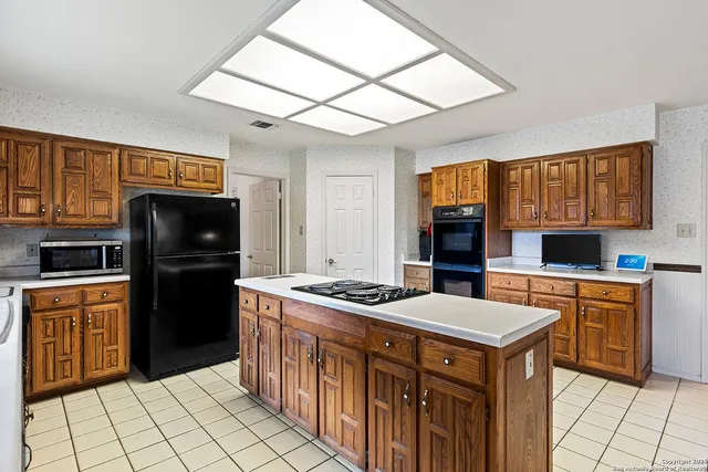 a room with a stove a washer and dryer