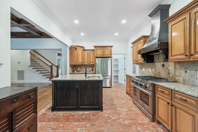 a kitchen with stainless steel appliances granite countertop a stove a sink and a refrigerator