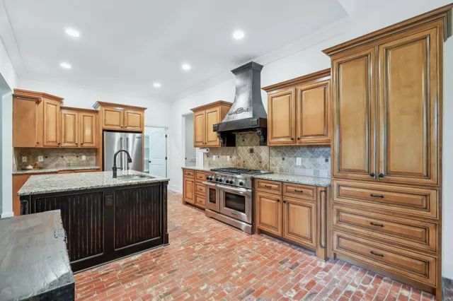 a kitchen with stainless steel appliances granite countertop a stove sink and cabinets