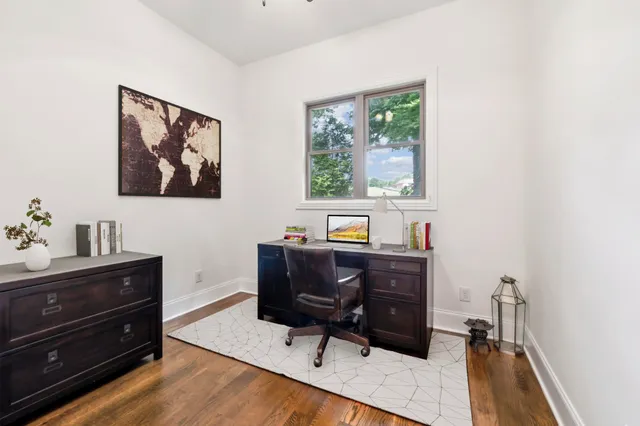 a view of a workspace with furniture and a window