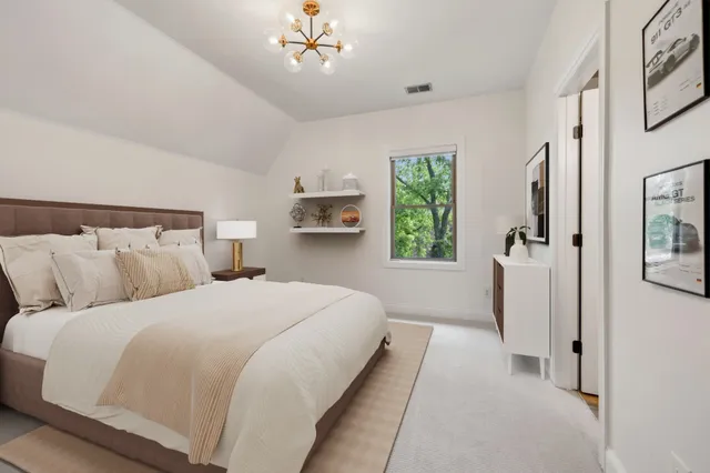 a bedroom with bed and a chandelier