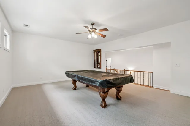 a room with pool table and a ceiling fan