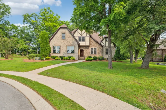a front view of a house with a yard and trees