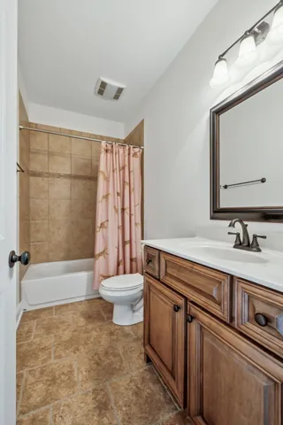a bathroom with a sink a toilet a mirror and shower