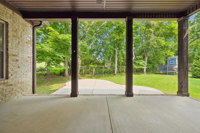a view of swimming pool with lawn chairs and floor to ceiling window