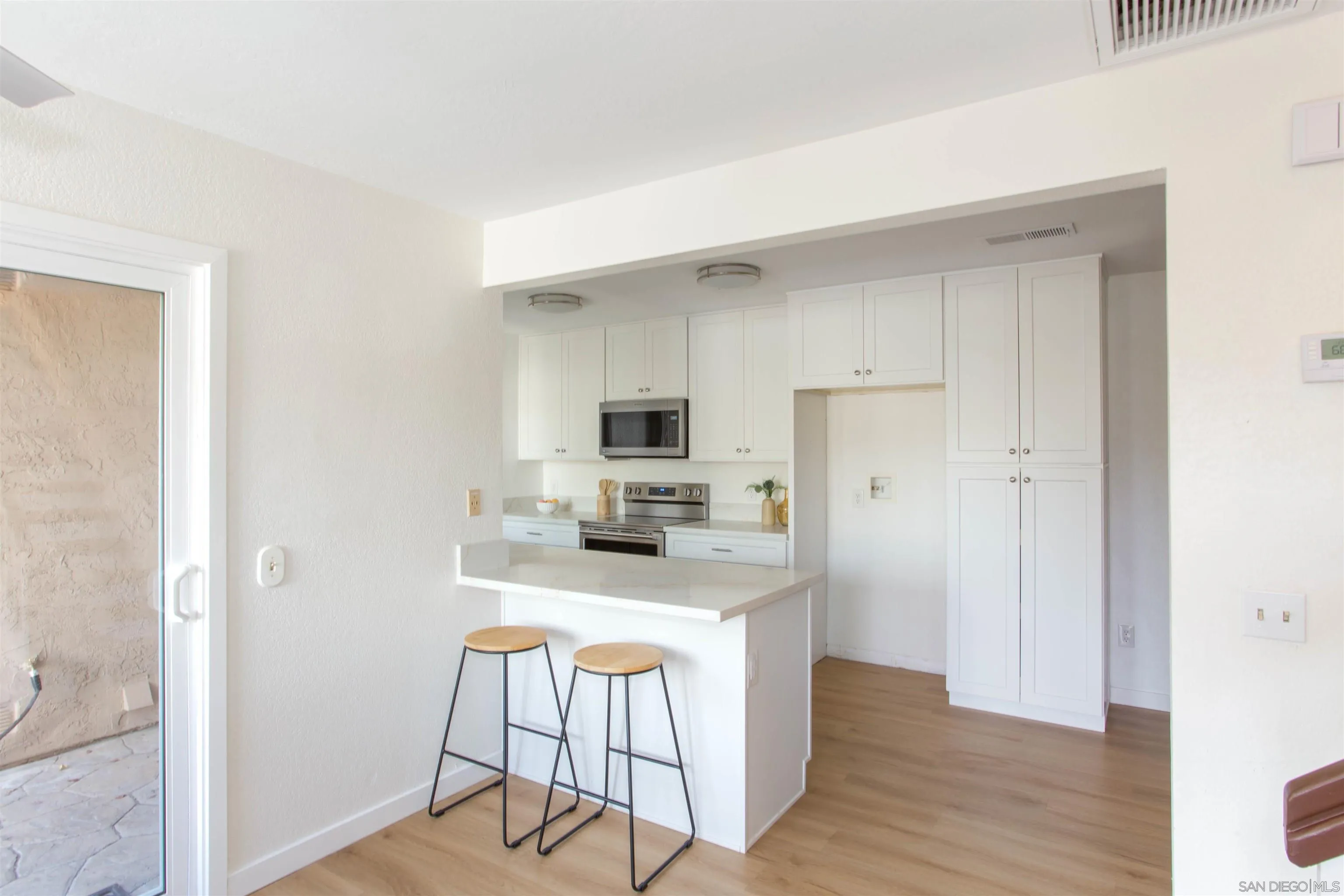 13650 Mulberry Tree Court Poway, CA 92064 - Photo 7 of 26 a kitchen with kitchen island white cabinets and stainless steel appliances