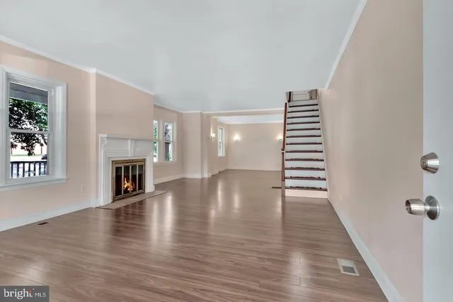a view of a hallway with wooden floor and windows
