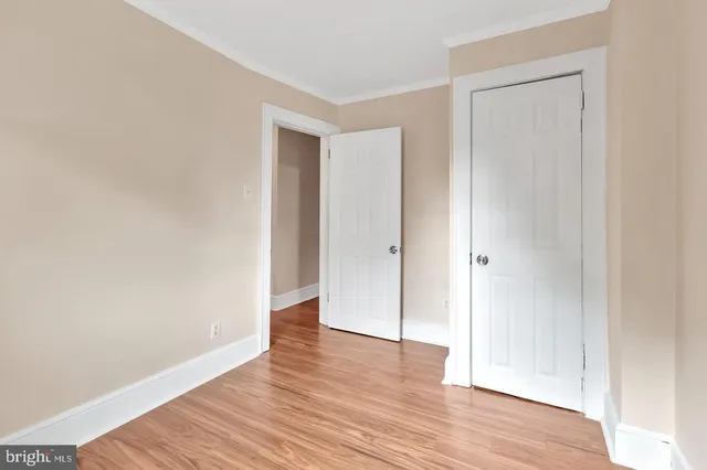a view of a hallway with wooden floor and entryway