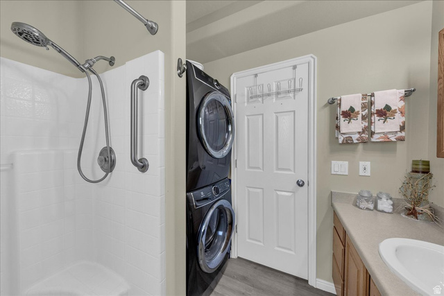 2990 East Riverside Drive, Unit 166 St. George, UT 84790 - Photo 15 of 22 Bathroom featuring vanity, stacked washing machine and dryer, light wood-style floors, and a shower stall