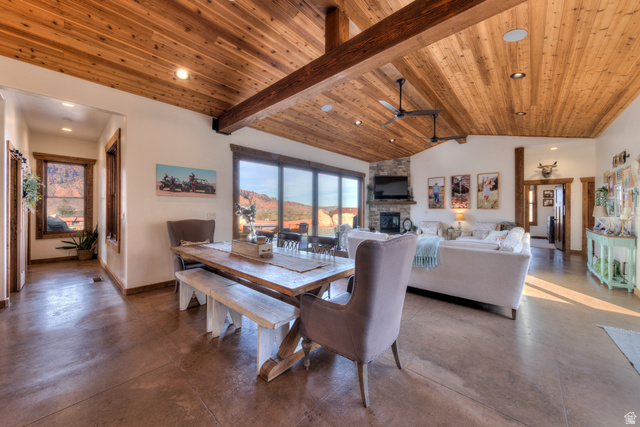 4173 Shadowfax Run, Unit 5 Moab, UT 84532 - Photo 11 of 41 Dining room featuring concrete flooring, a ceiling fan, a stone fireplace, a high wood beamed ceiling, and recessed lighting