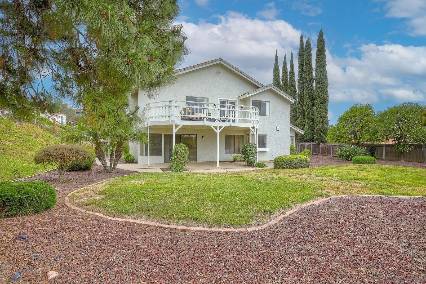 17834 St Andrews Drive Poway, CA 92064 - Photo 36 of 38 a view of a white house next to a yard with big trees