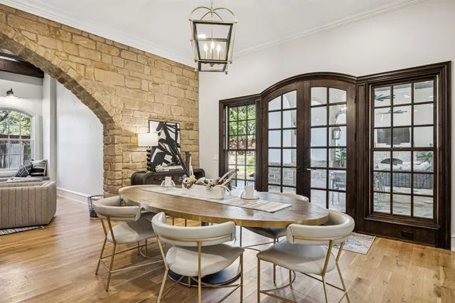 a kitchen with stainless steel appliances kitchen island granite countertop a table chairs in it and white cabinets