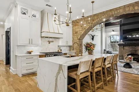 a kitchen with stainless steel appliances granite countertop a sink a stove and cabinets
