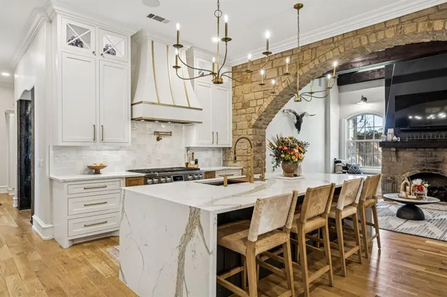 a kitchen with stainless steel appliances granite countertop a sink a stove and cabinets