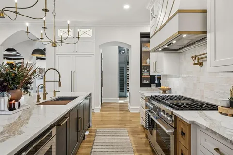 a kitchen with sink a stove and cabinets