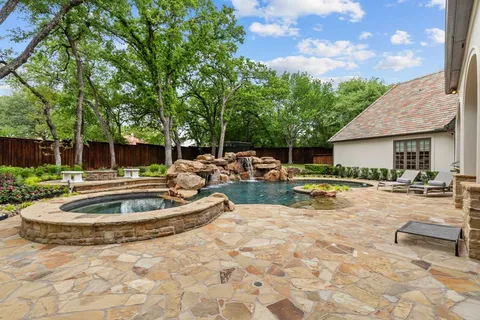 a view of house with swimming pool and a yard in the background