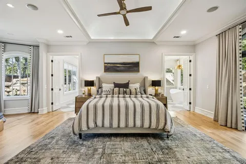 a bedroom with a bed a mirror and a fireplace