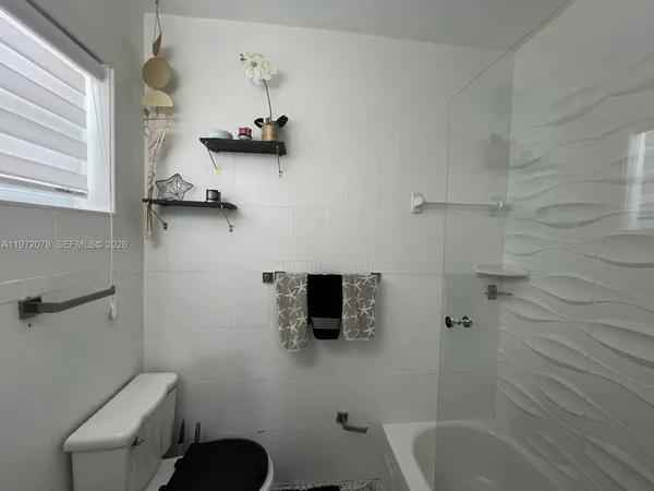 a bathroom with a shower a toilet and a bathtub