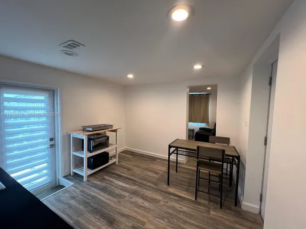 a view of a workspace with furniture and wooden floor
