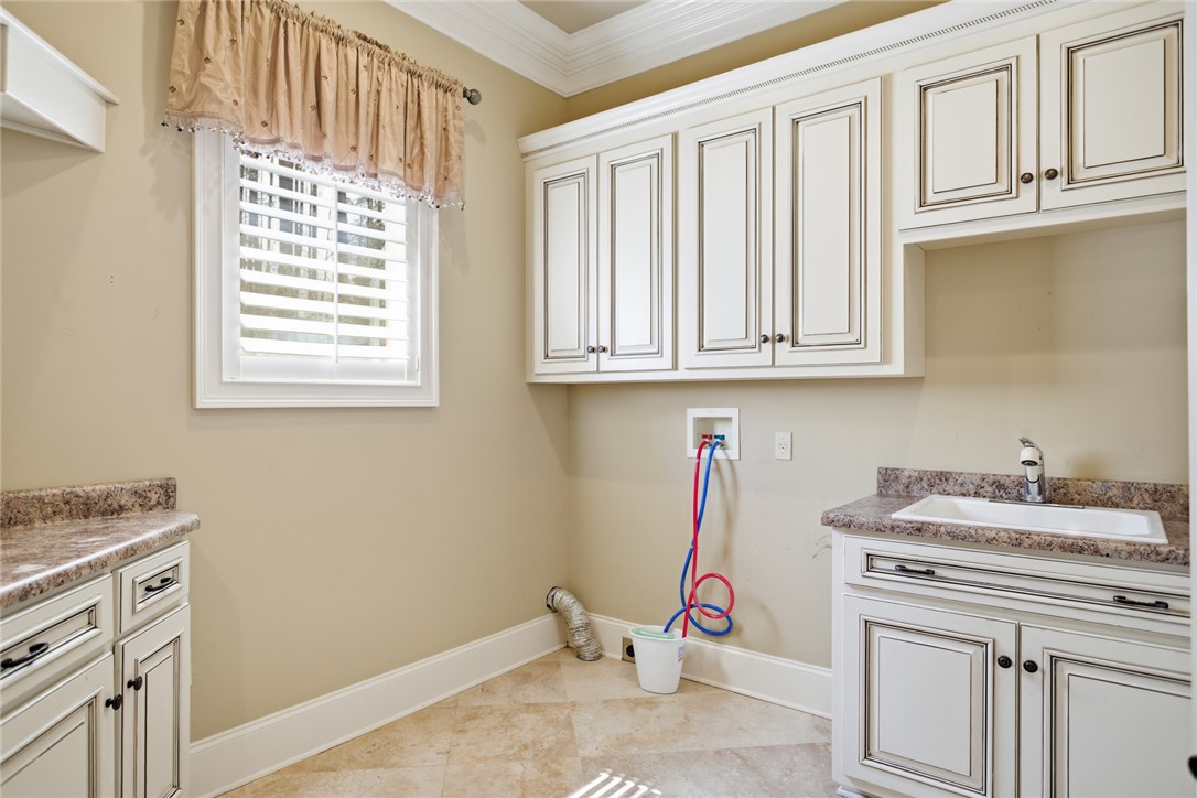 610 Highridge Drive Seneca, SC 29672 - Photo 24 of 50 This dedicated laundry space offers practical storage and a functional utility sink.