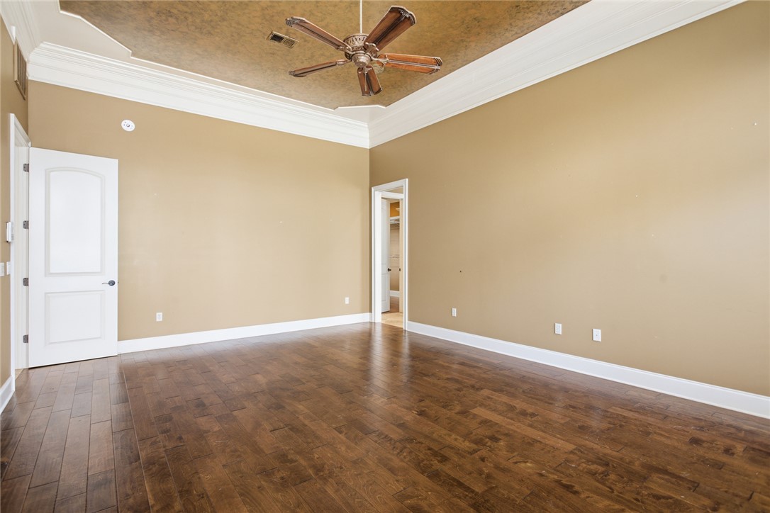 610 Highridge Drive Seneca, SC 29672 - Photo 27 of 50 This spacious primary bedroom features rich wood flooring and an elegant tray ceiling, perfect for comfortable living.