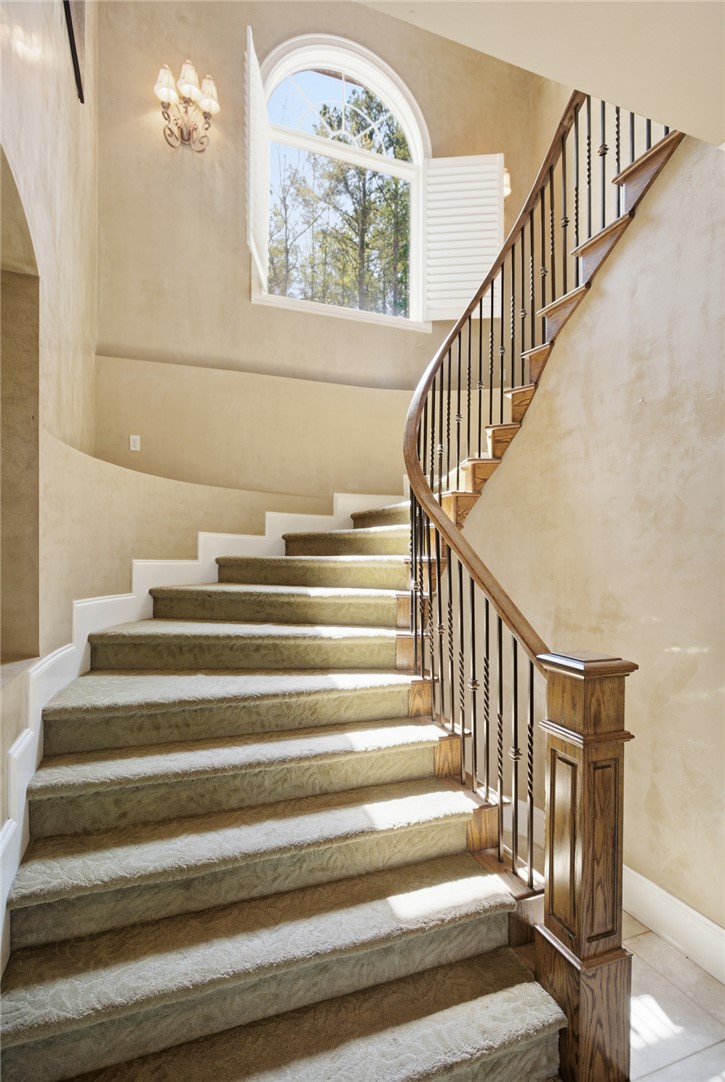610 Highridge Drive Seneca, SC 29672 - Photo 32 of 50 Elegant spiral staircase with carpeted treads and an arched window, creating a grand entrance.