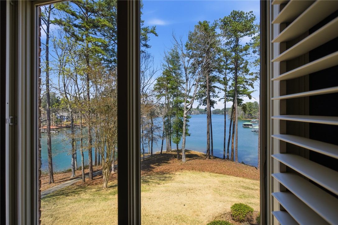 610 Highridge Drive Seneca, SC 29672 - Photo 49 of 50 Framed by elegant shutters, this window offers serene Lake Keowee and lush tree views.