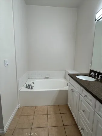 a spacious bathroom with a bathtub sink vanity and mirror
