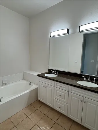 a spacious bathroom with a granite countertop sink and a bathtub