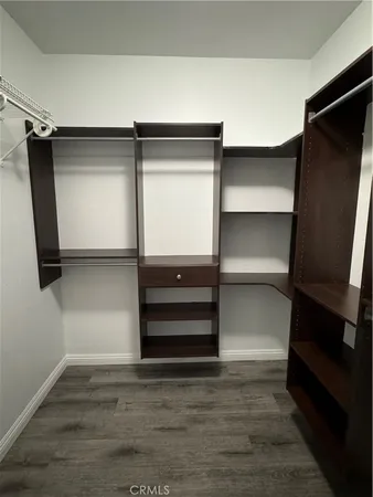 a view of walk in closet with empty racks