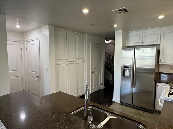 a kitchen with stainless steel appliances granite countertop a refrigerator and a sink