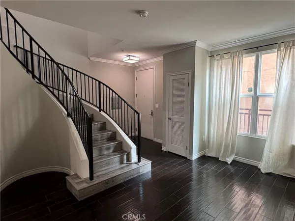 a view of entryway with wooden floor and stairs