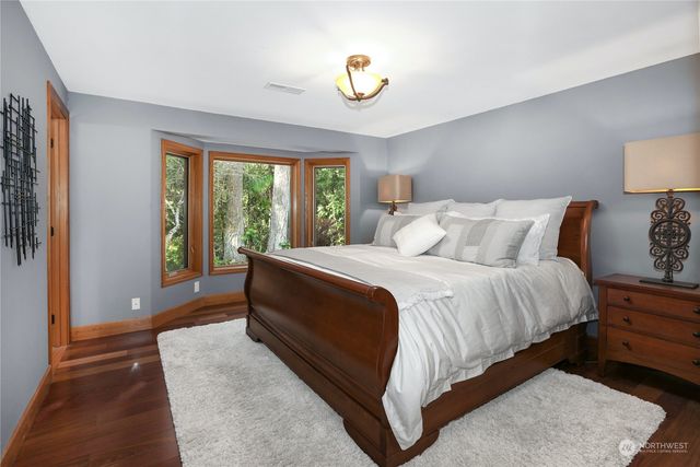 a bedroom with a bed and painting on the wall