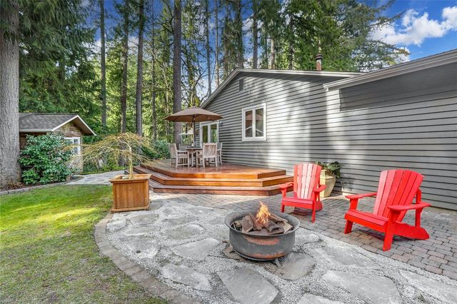 a backyard of a house with fire pit and outdoor seating