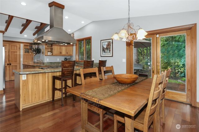 a view of a dining room and livingroom with furniture wooden floor a chandelier