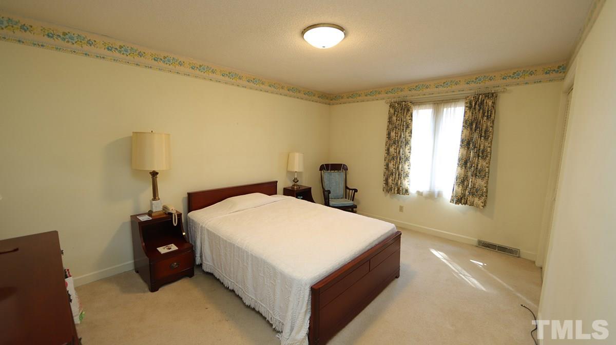 210 Queensferry Road Cary, NC 27511 - Photo 10 of 14 a bed sitting in a spacious bedroom next to a window