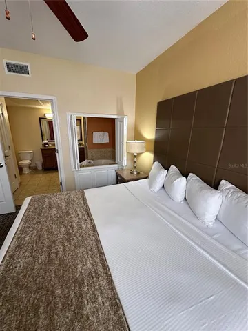 a bedroom with a bed and a large mirror on the dresser