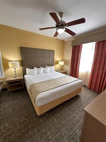 a bedroom with a bed and a ceiling fan