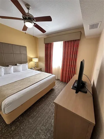 a bedroom with a bed a lamp and a large window