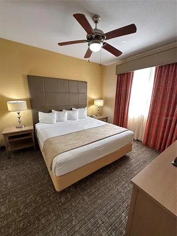 a bedroom with a bed and a ceiling fan