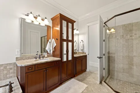 a bathroom with a double vanity sink mirror and shower