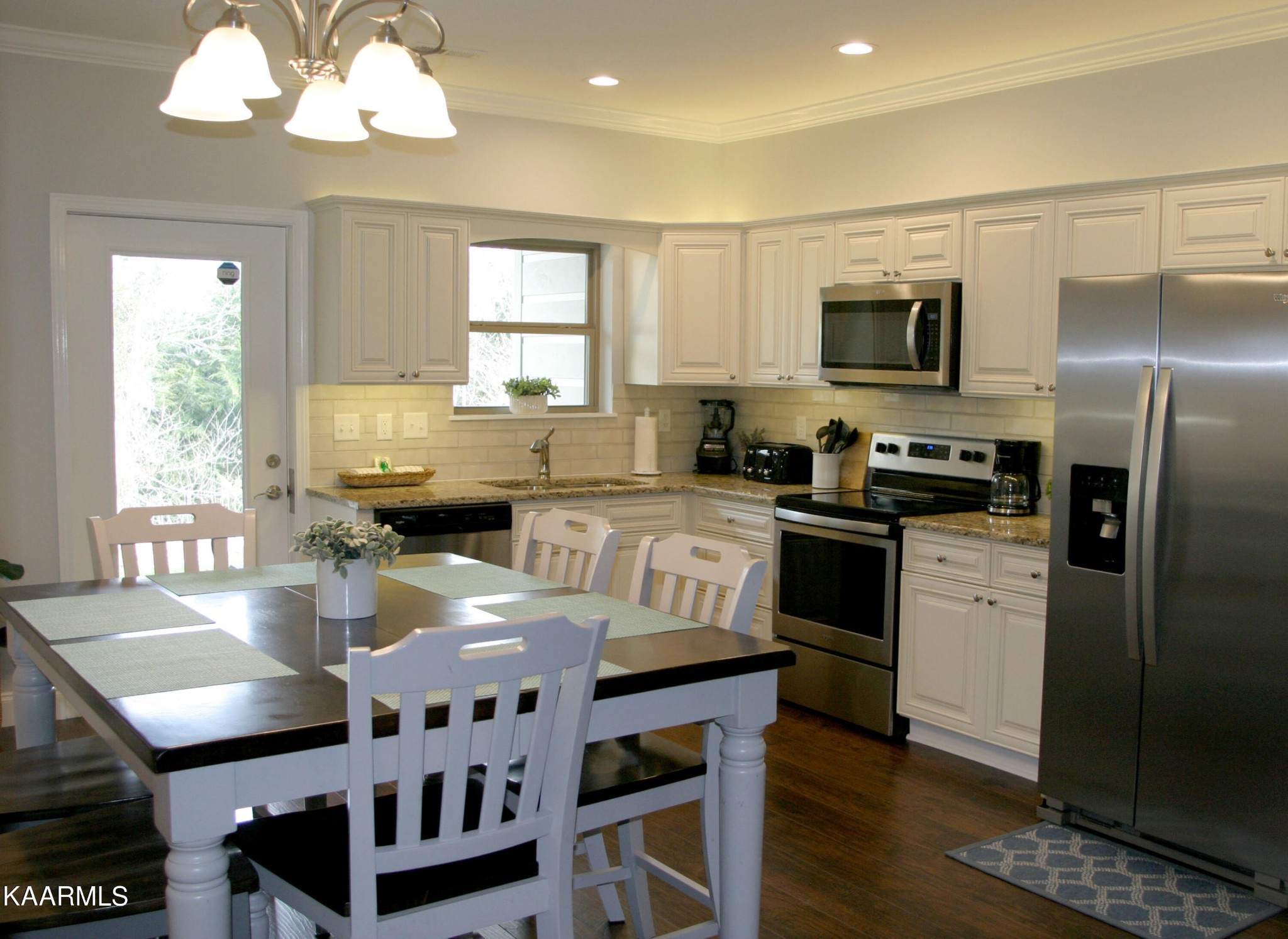 326 Shooting Star Loop, Unit 102 Townsend, TN 37882 - Photo 6 of 22 a kitchen with stainless steel appliances granite countertop a stove a sink a microwave a refrigerator and white cabinets with wooden floor
