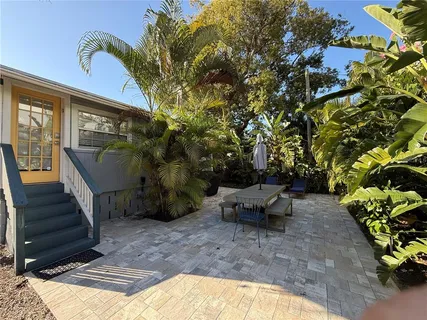 a view of a patio with table and chairs with wooden floor and plants