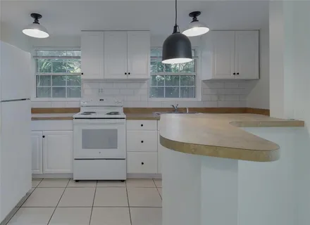 a kitchen with a stove cabinets and window