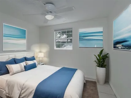 a bedroom with bed and a potted plant