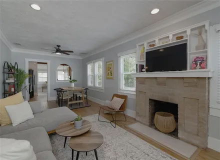 a living room with furniture a fireplace and a flat screen tv