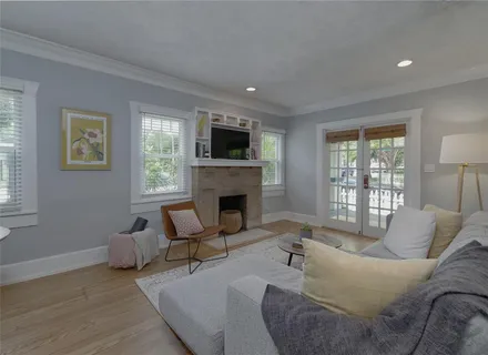 a living room with furniture a flat screen tv and a fireplace